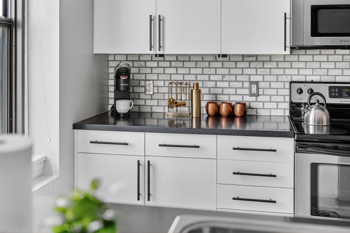 Sleek and functional—your modern kitchen comes stocked with essentials, including a Keurig, barware, and plenty of prep space for takeout or home-cooked meals.