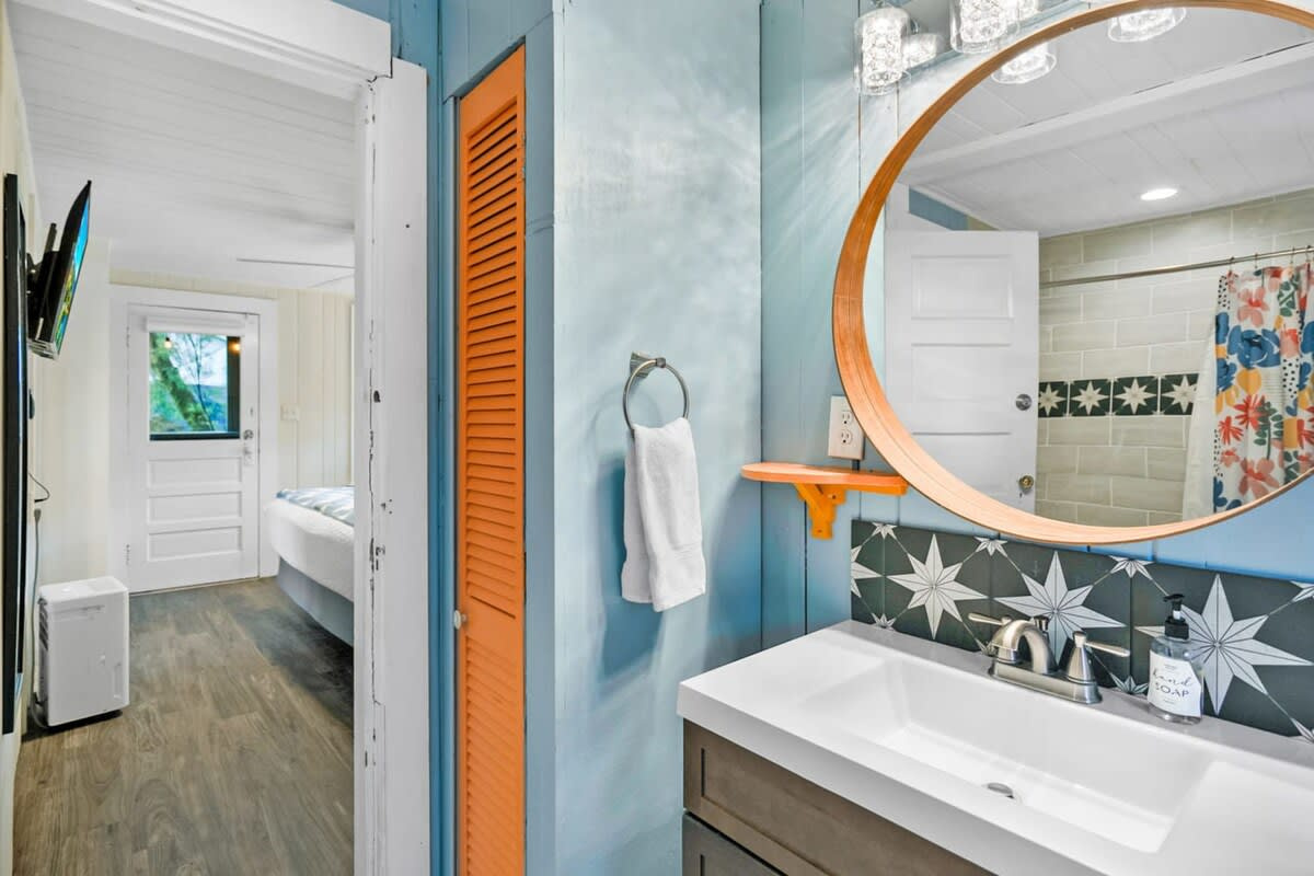 Bright tile, a big mirror and plenty of counter for everybody's things. The bathroom carries the same fearless colour as the rest of the cottage, which somehow makes even the ordinary bits feel like a holiday.
