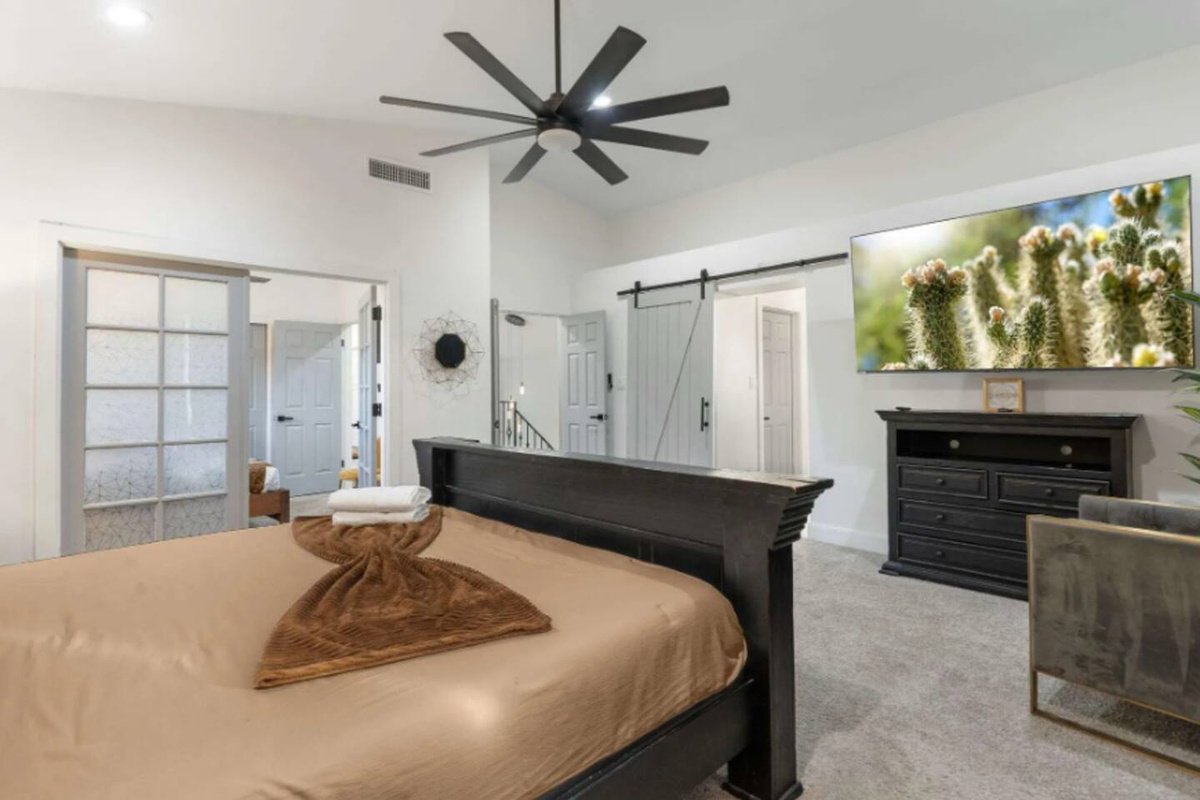 Spacious bedroom with smart TV and entertainment space.