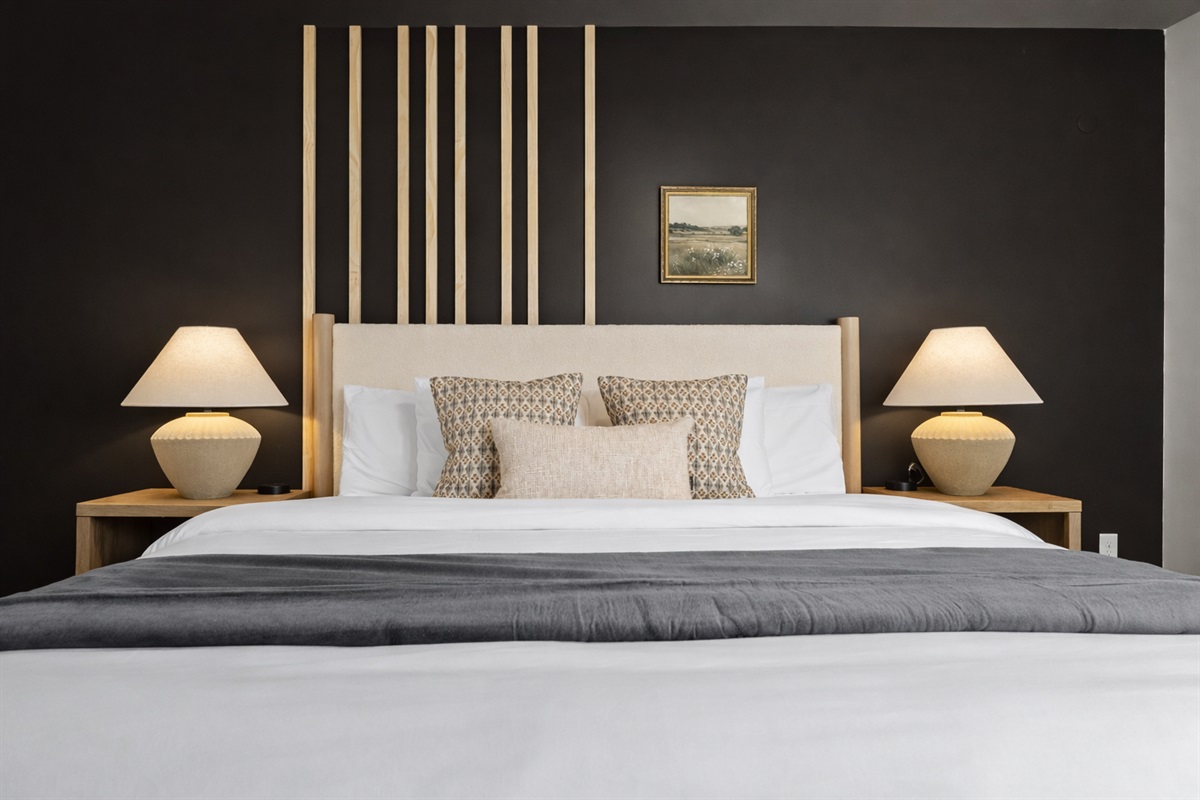 Serene bedroom with plush bedding, warm lighting, and modern accents—designed for restful nights and a cozy, hotel-style stay.