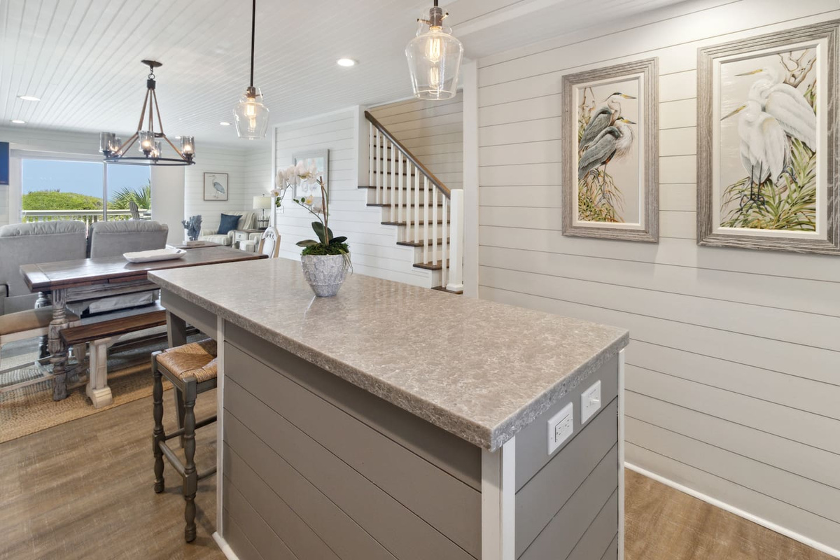 The kitchen island is the social hub &mdash; bar seating right there while someone cooks, Gulf breeze drifting in.