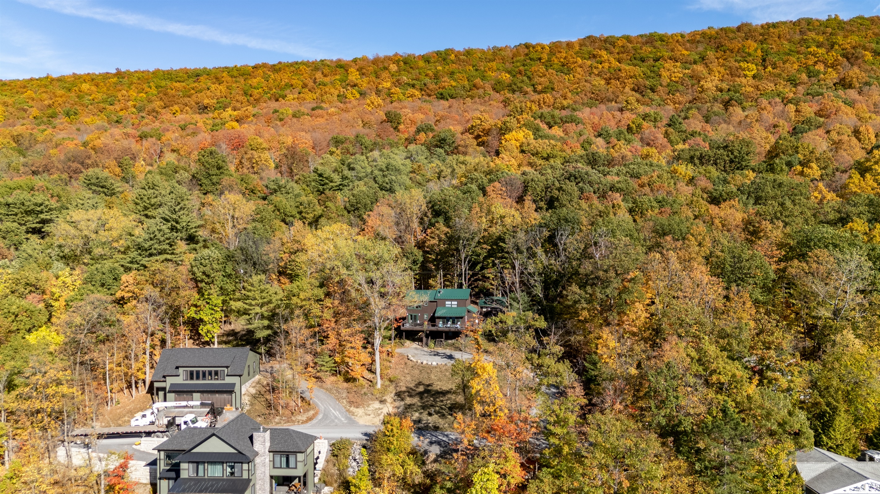 A stunning hillside view showcases your secluded getaway surrounded by autumn colors and lake serenity.