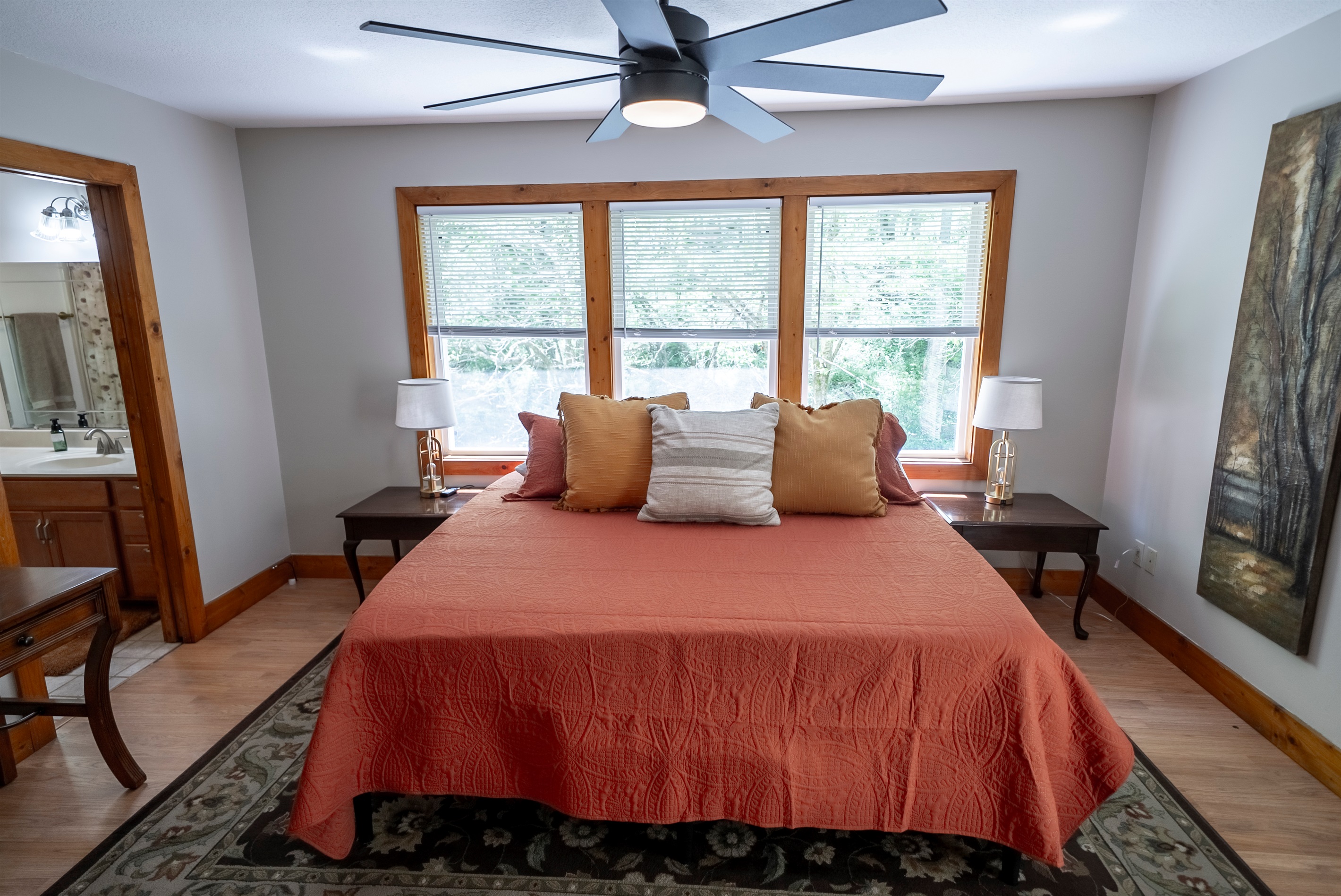 Wake up to peaceful creek views from the king bedroom, complete with large windows, direct access to the deck, a Smart TV, ceiling fan, and private en suite.
