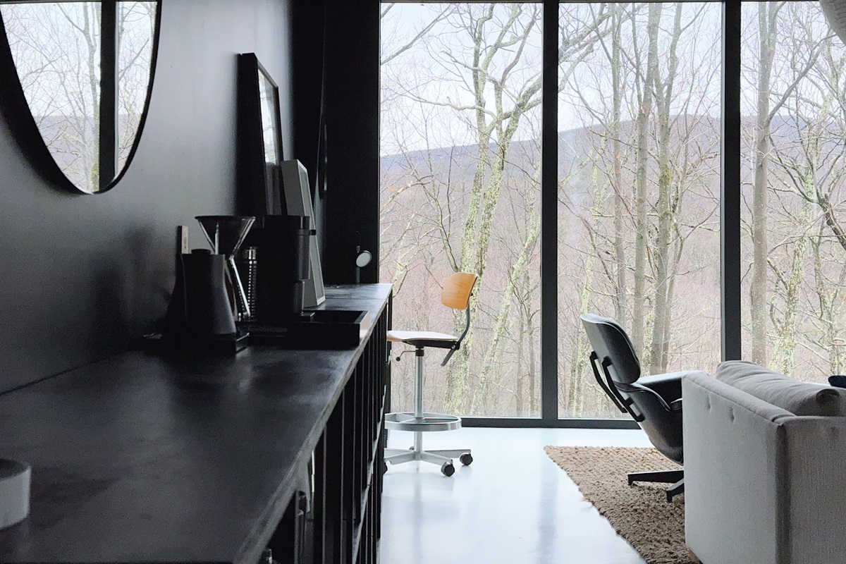 Desk setup with vintage Danish chair in living area.