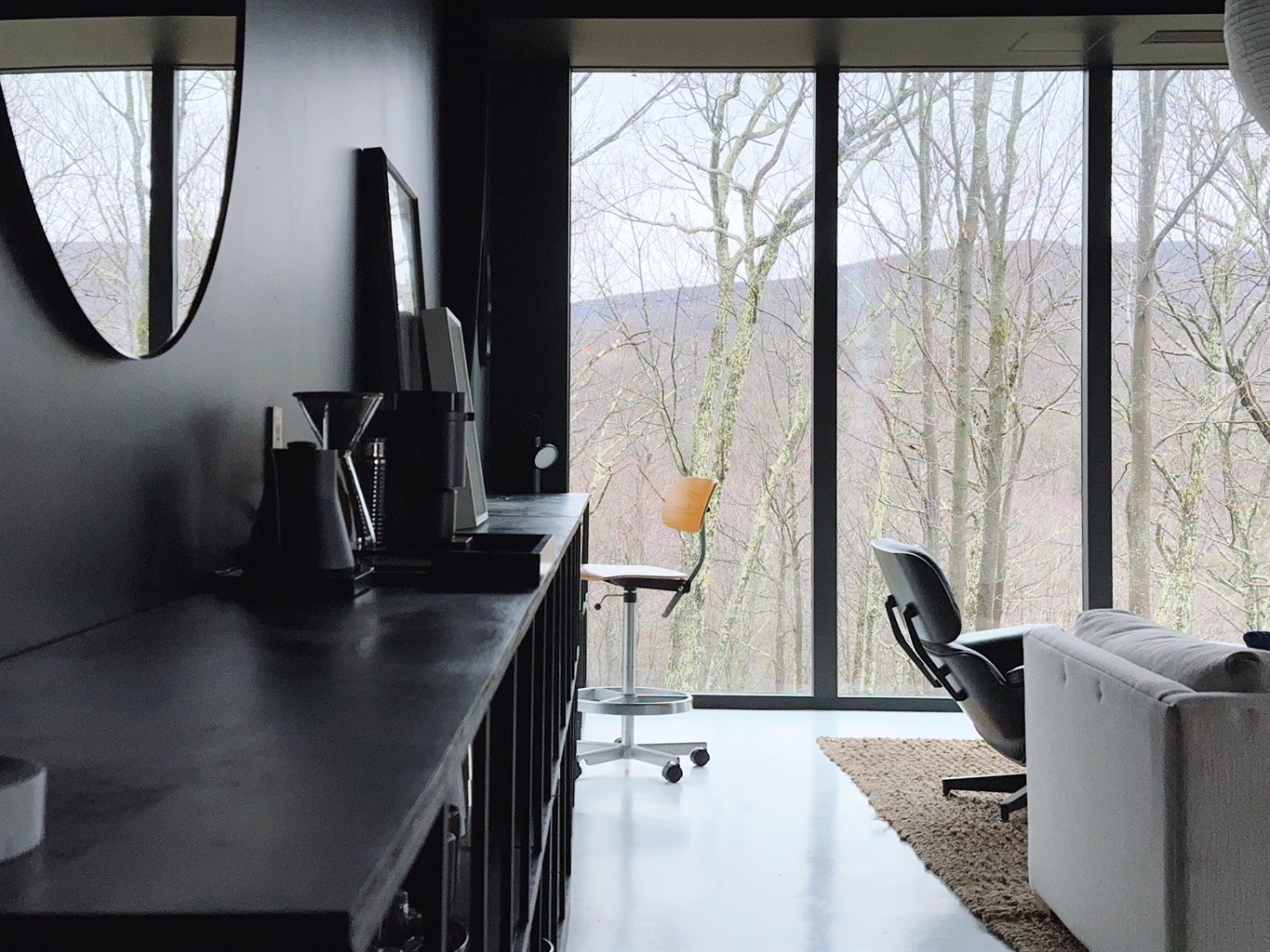 Desk setup with vintage Danish chair in living area.