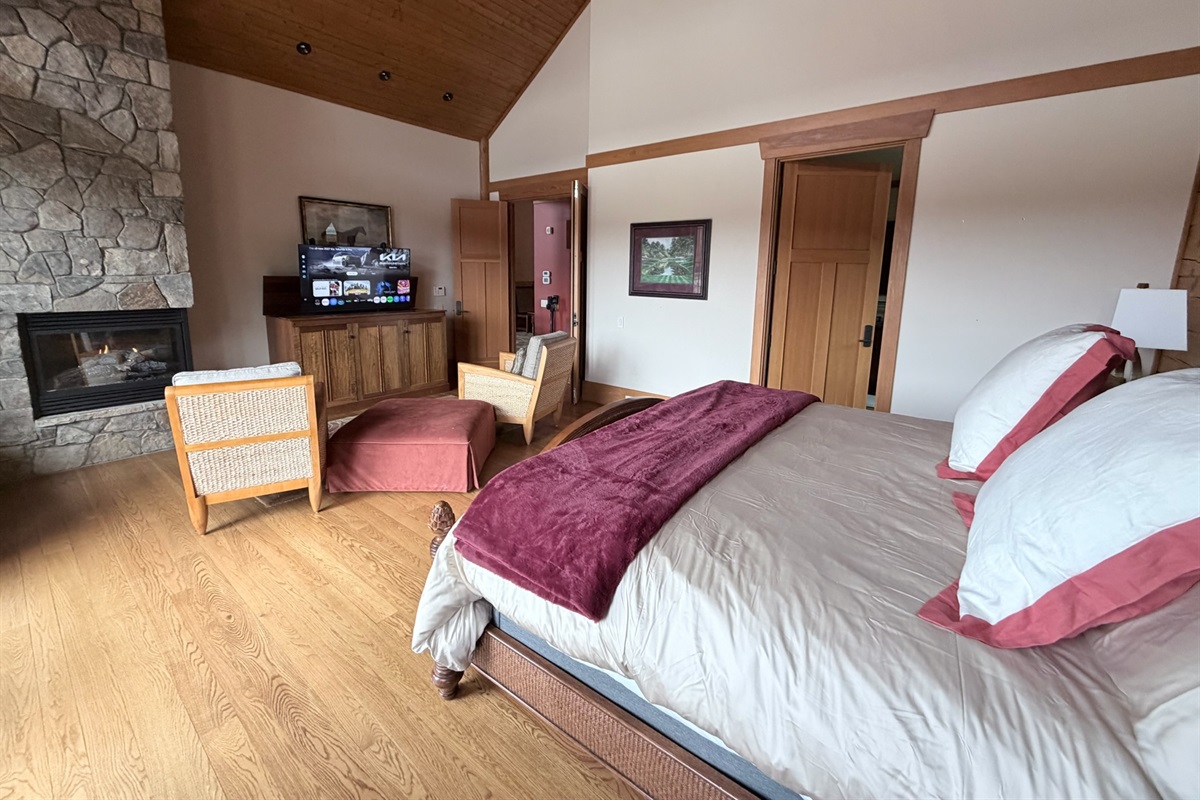 Spacious master bedroom featuring a comfortable king bed and a cozy propane fireplace