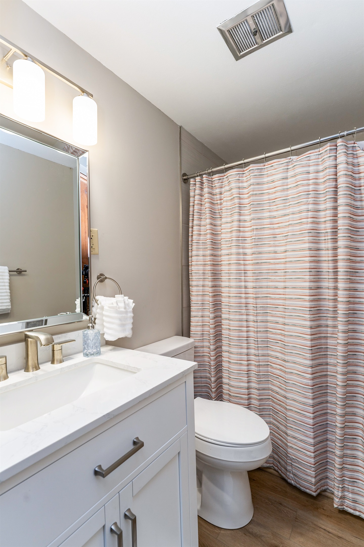 Fresh and modern bathroom with sleek fixtures, a marble vanity, and a cozy shower/tub combo—perfect for unwinding after a day of exploring.