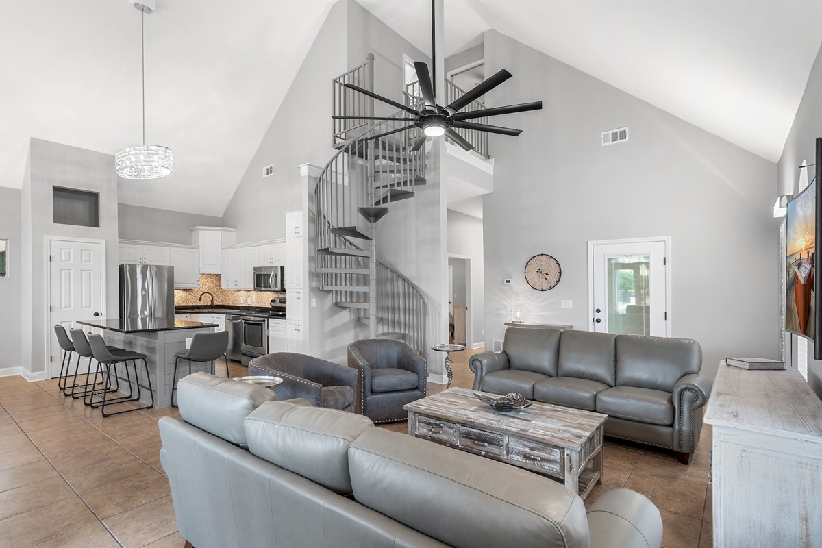 Open‑concept living area with vaulted ceilings and modern coastal décor