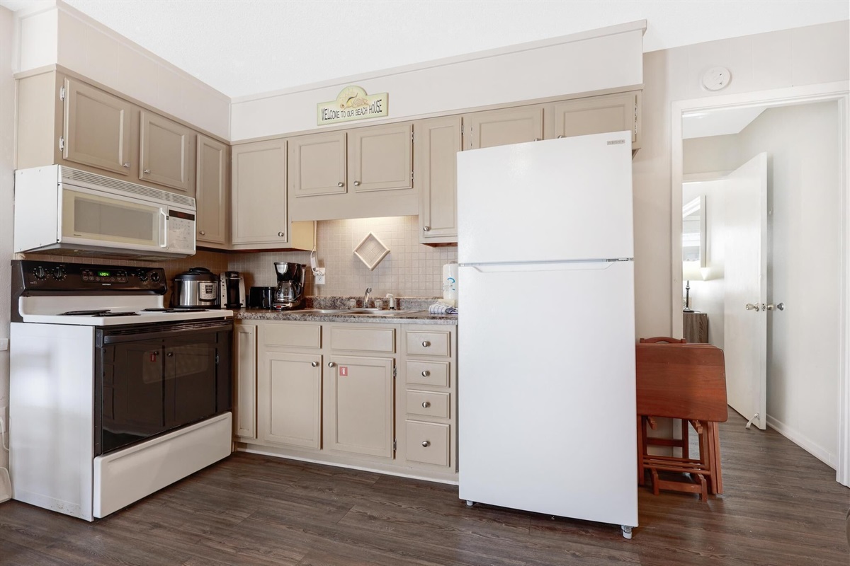 Kitchen - The spacious kitchen features electric appliances, which include a built-in microwave, stove, and refrigerator. Fully stocked with many items you will need for preparing meals during your stay.
