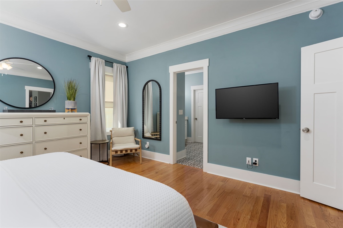 Primary suite with wall-mounted TV and easy access to the en suite bathroom.