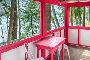 Indoor living with two chairs and one table with a great view to the lake.
