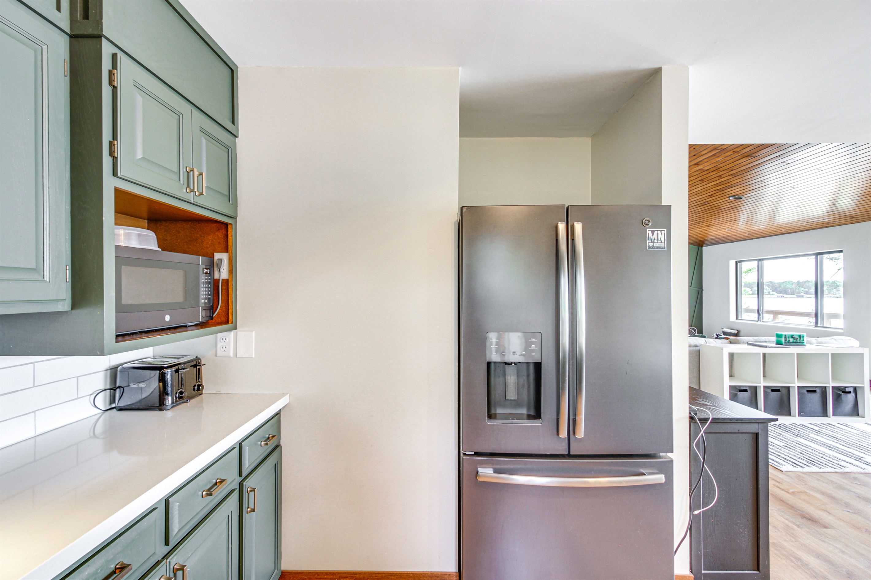 Fully equipped kitchen with stainless steel refrigerator, microwave, and ample counter space