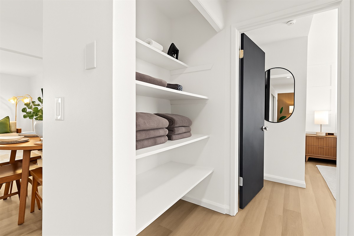 Stay organized during your stay with open shelving stocked with towels, an iron, and other essentials.