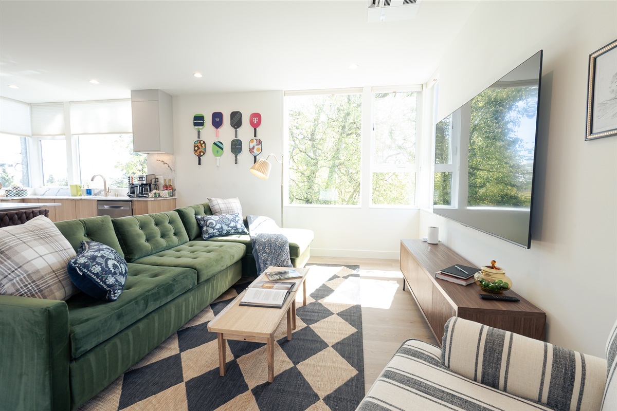 The open concept common area has space for everyone to enjoy the beautiful Seattle light. Peep the pickleball wall!
