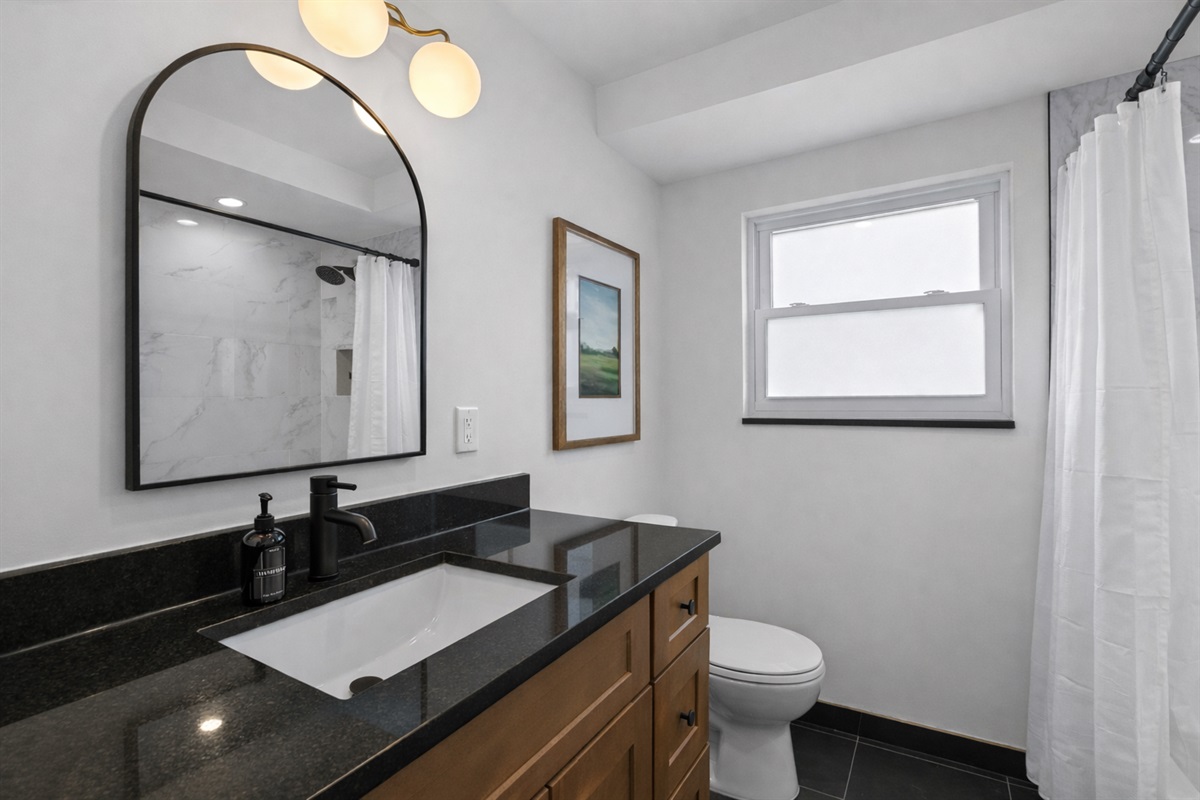 Refresh in this modern bathroom featuring a sleek vanity, bright lighting, and a clean walk-in shower—designed for comfort, style, and easy mornings.