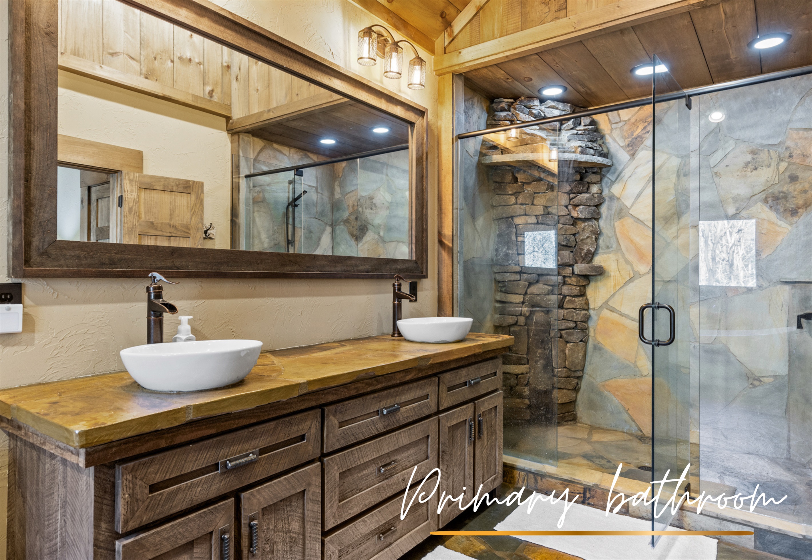 The primary en-suite bathroom features sleek stone accents, modern fixtures, and plenty of space for a spa-like experience.