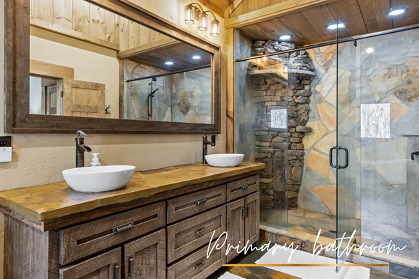 The primary en-suite bathroom features sleek stone accents, modern fixtures, and plenty of space for a spa-like experience.