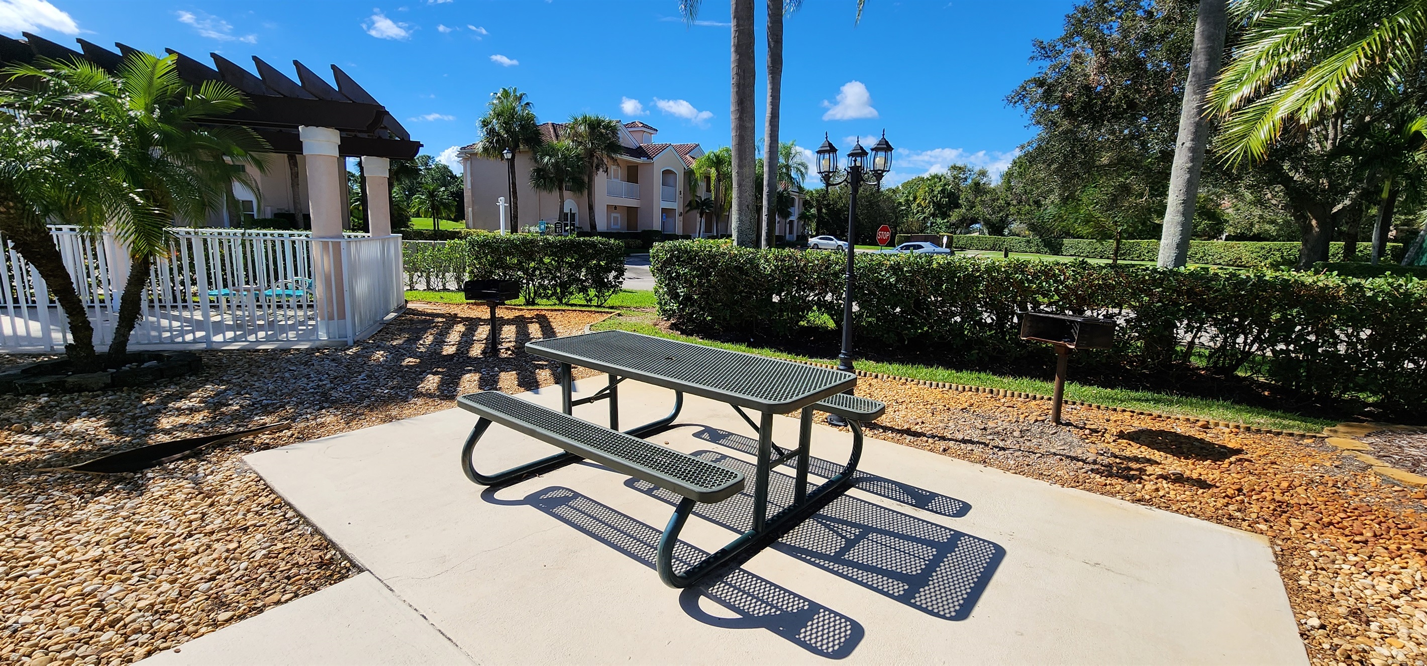 Outdoor community picnic area with shaded seating, landscaped surroundings, and convenient access near the pool.