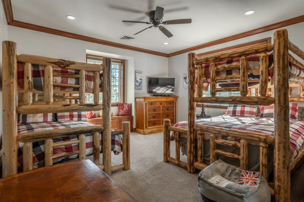 Fun bunk room with multiple log-style bunks and TV — perfect for kids or groups.