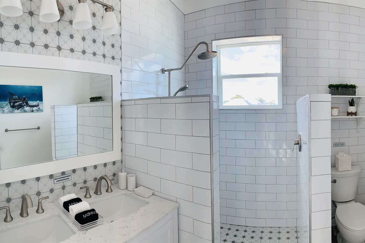 MERMAID COVE Bright bathroom with double vanity, large shower. We provide shampoo, conditioner, body wash, body lotion, plenty of towels, bath robes and blow dryer.