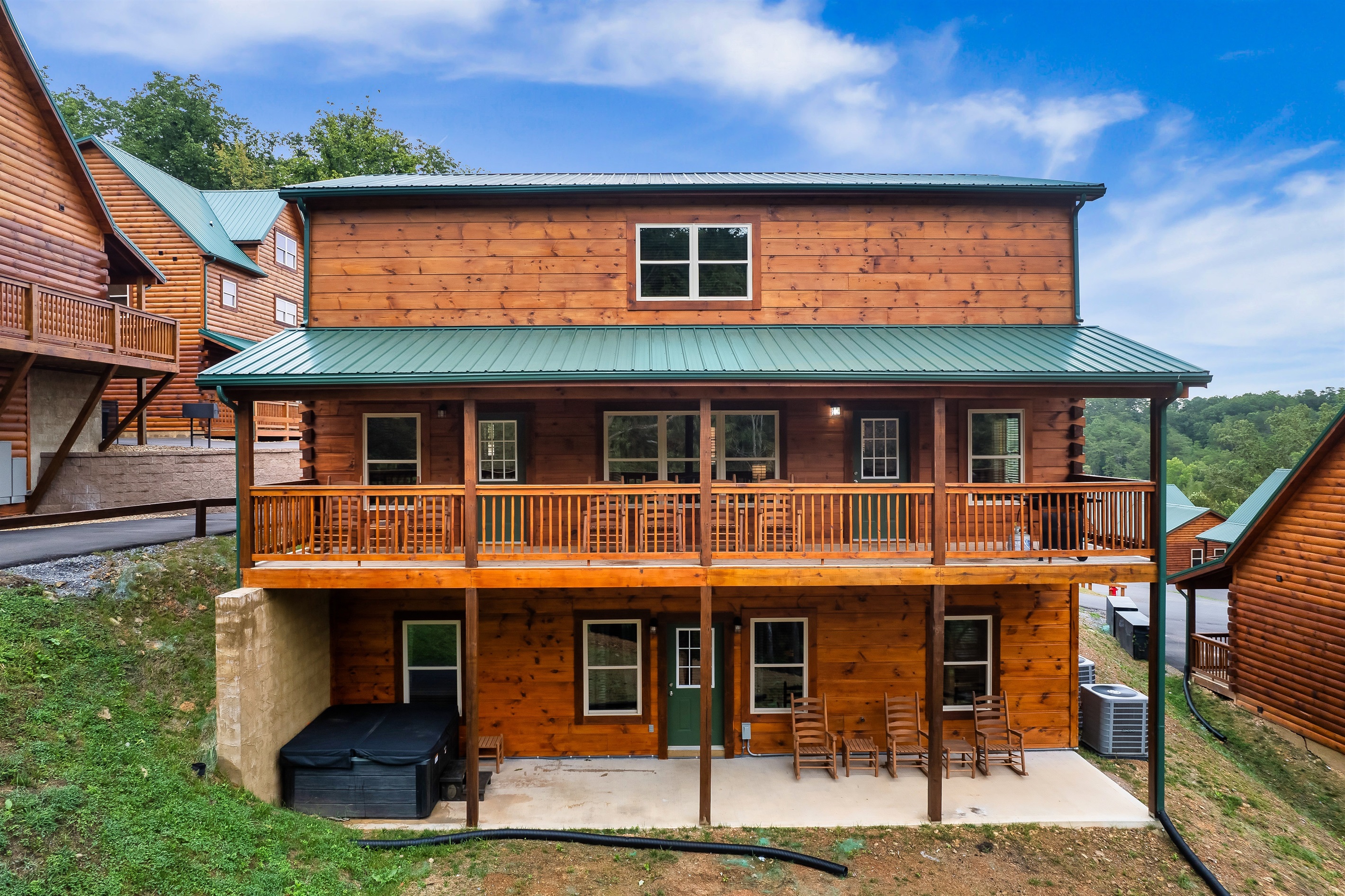 Back side with patio, balcony and hot tub.