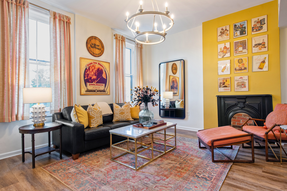 The Pappy Suite living room, with a sofa, lounge chair and yellow accent wall.
