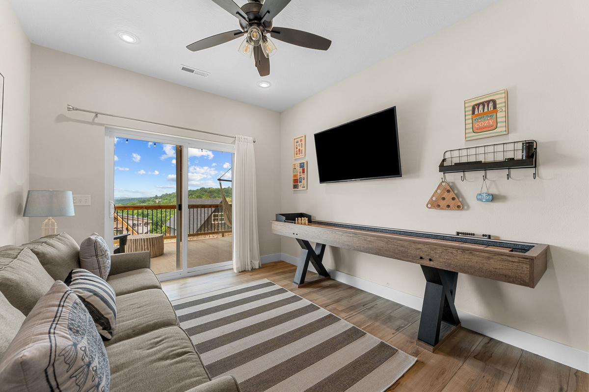 Living area with large TV screen and shuffleboard game