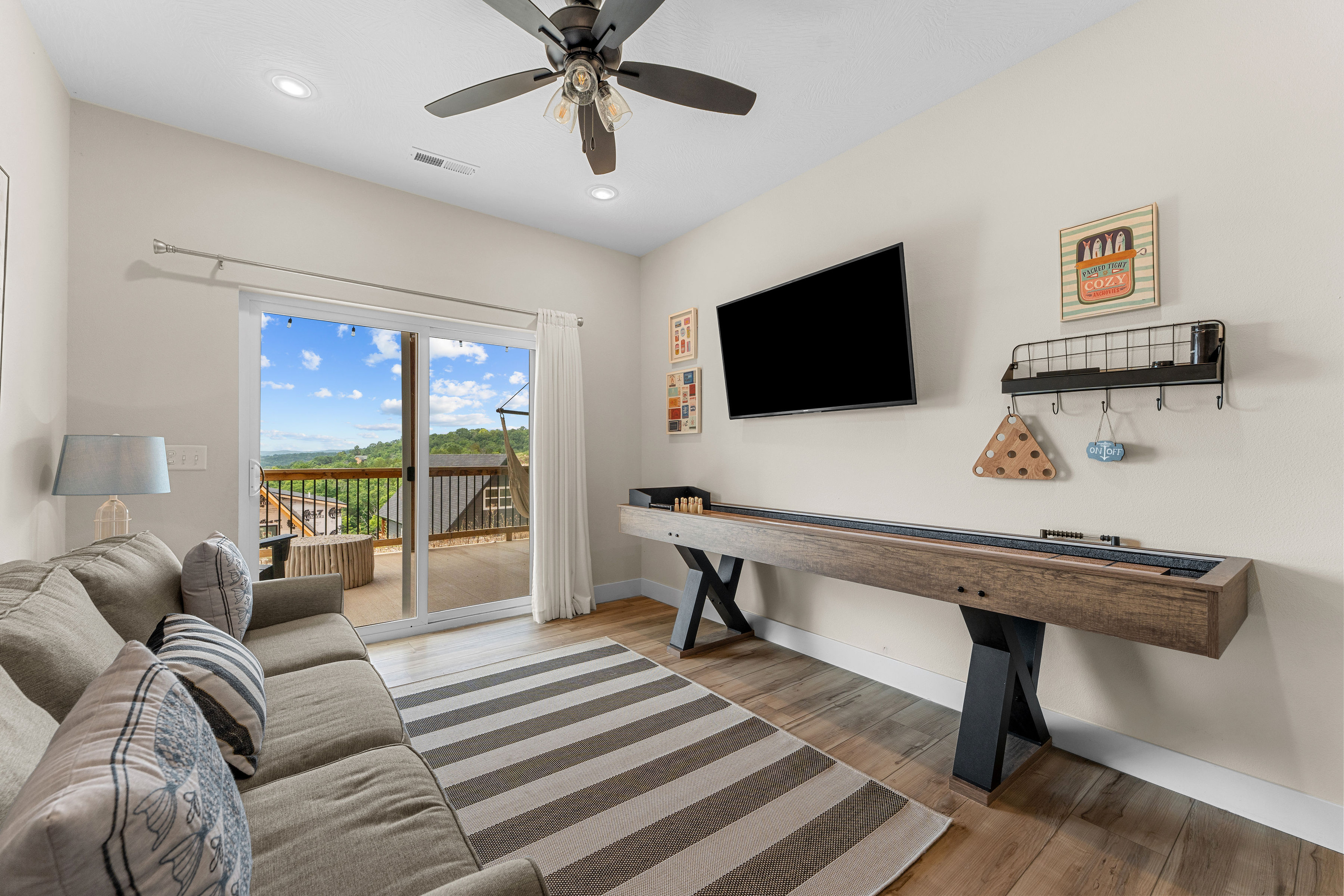 Living area with large TV screen and shuffleboard game