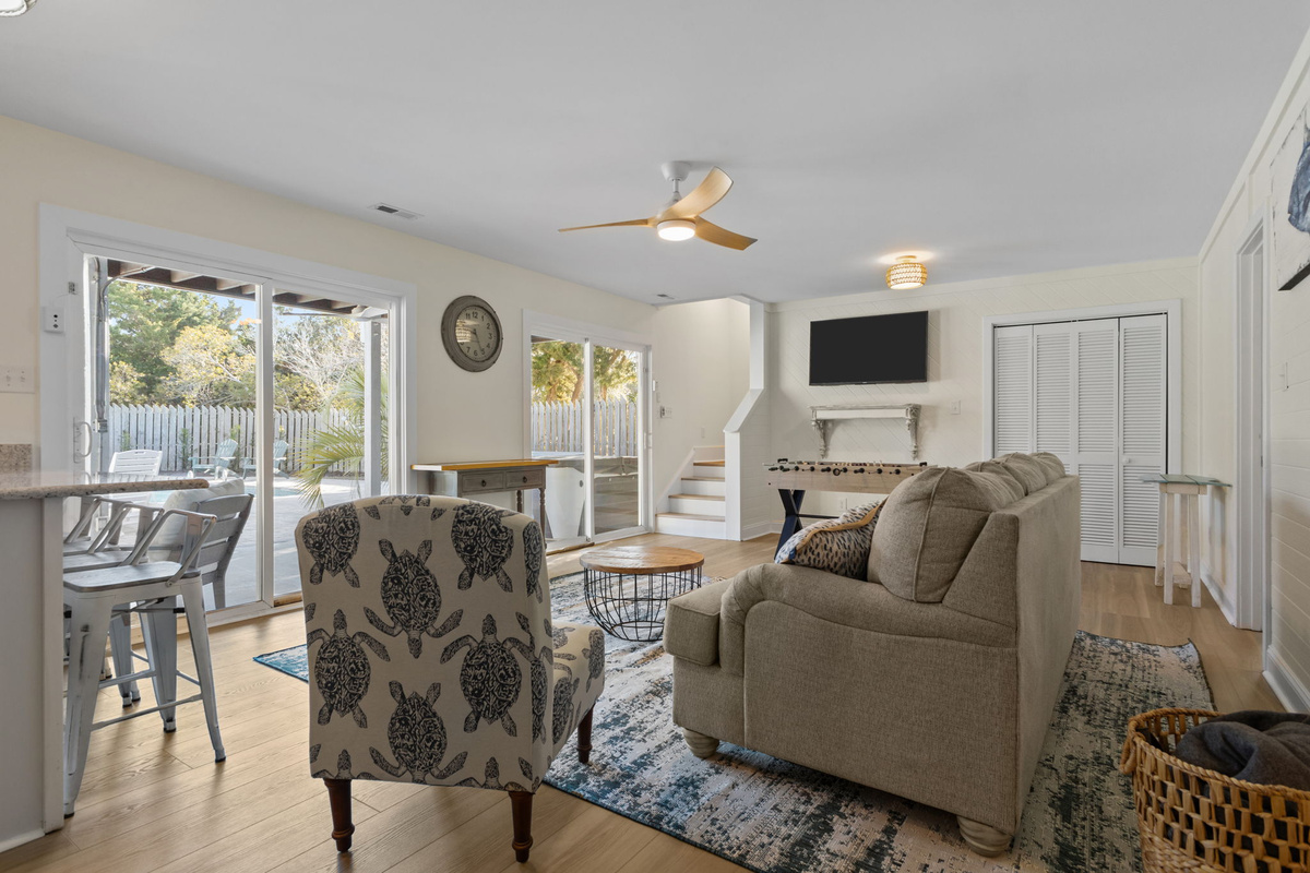 Sliding glass doors fill the space with natural light and provide seamless indoor-outdoor access to the backyard oasis