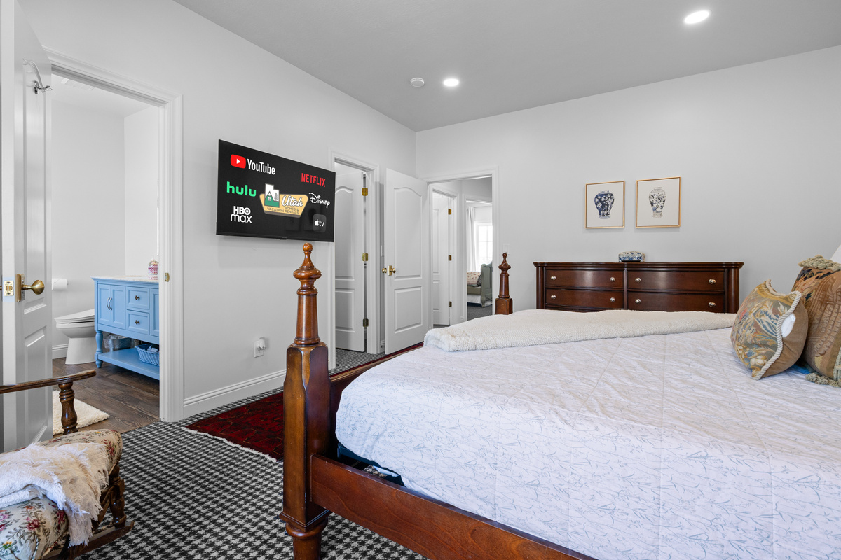 The primary bedroom offers an inviting blend of comfort and function, with refined furnishings, a full dresser, ensuite access, and abundant room to settle in.