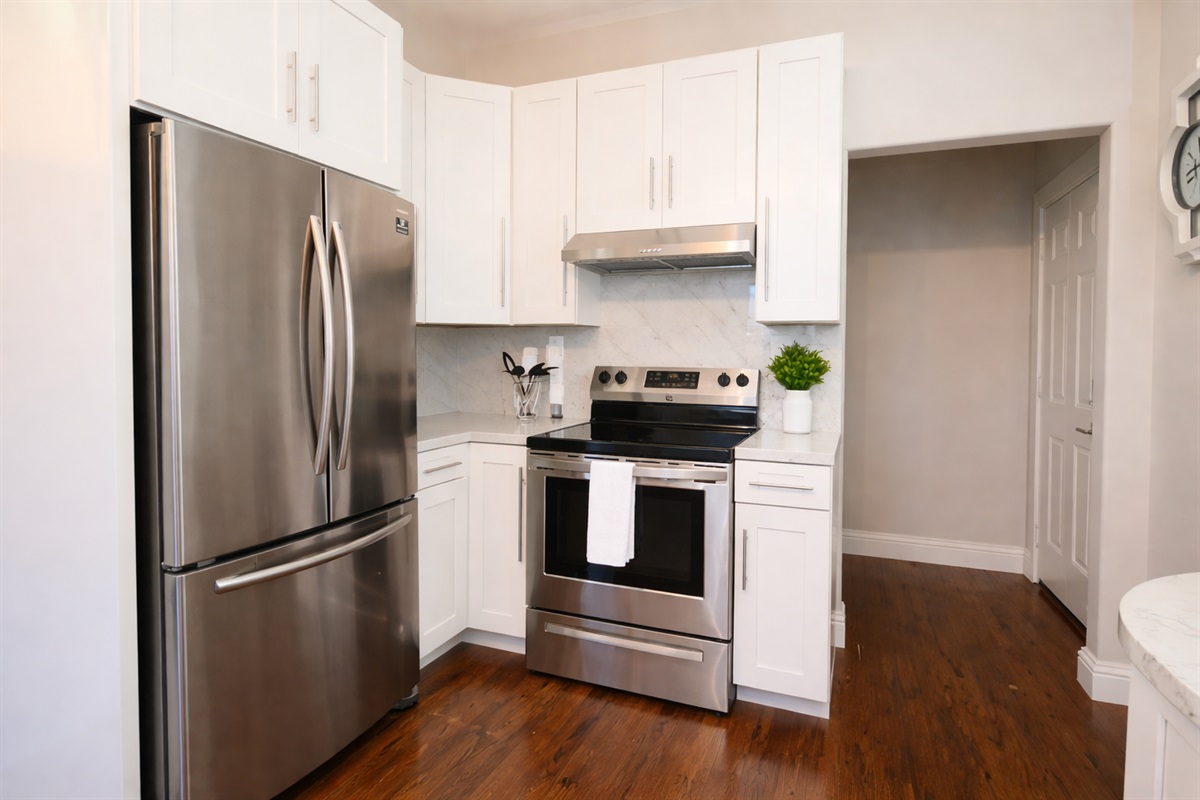 Modern convenience at your fingertips. Features include a deep stainless steel sink, a professional-grade range, and a spacious French-door refrigerator.