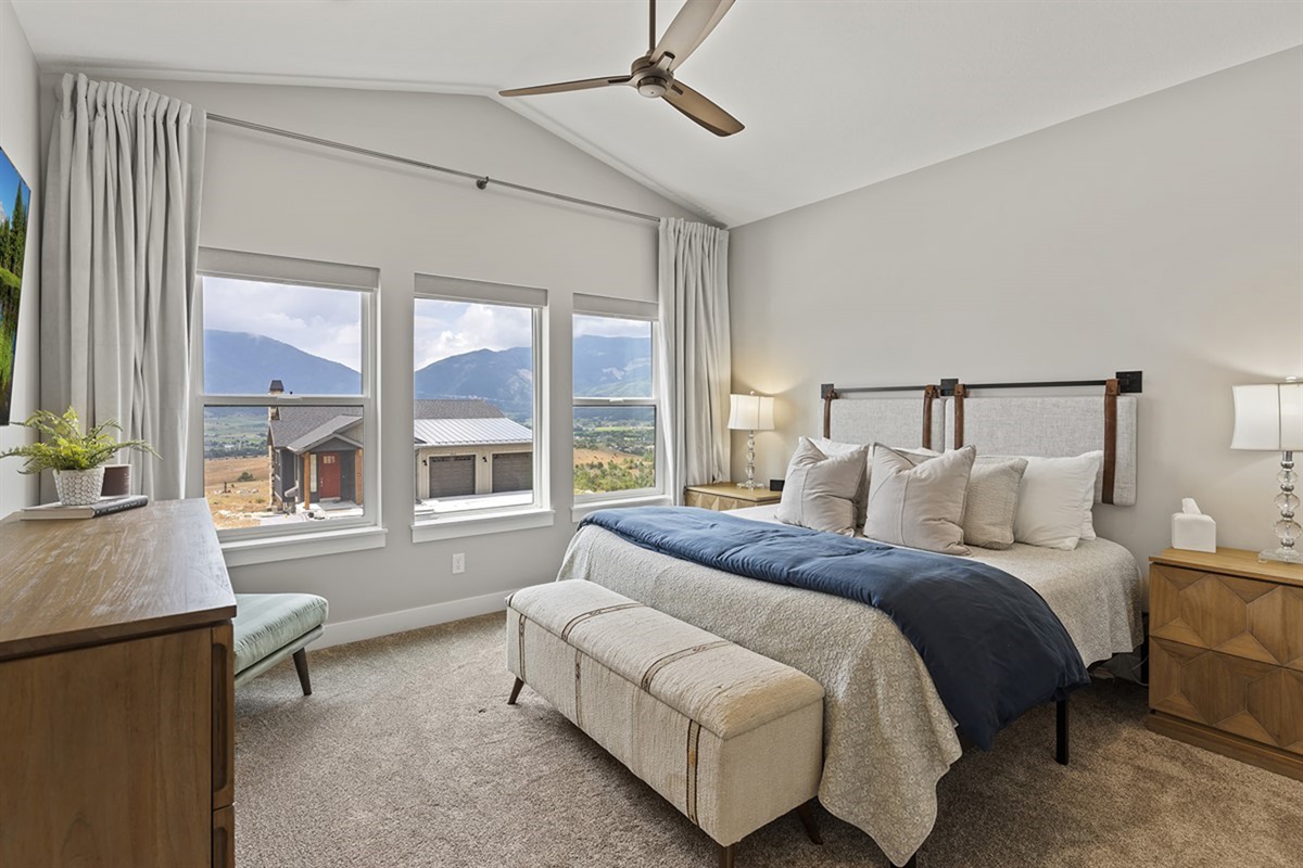 Peaceful primary bedroom with king bed, mountain views, and cozy seating.