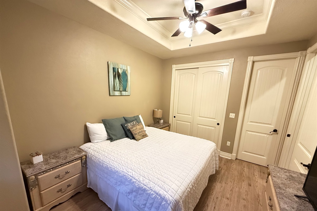 Comfortable queen bedroom with soft bedding, stylish décor, and ample closet space.