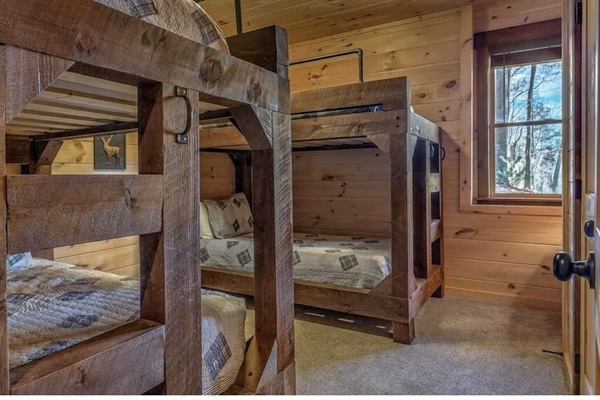 Bunk room with rustic wood beds and cozy sleeping spaces. Perfect for kids or extra guests on your mountain getaway.