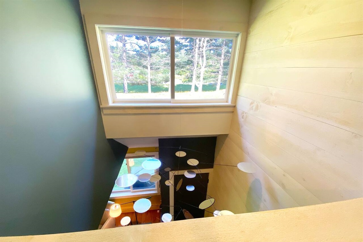 Hallway, filled with natural light and reflecting mobile.