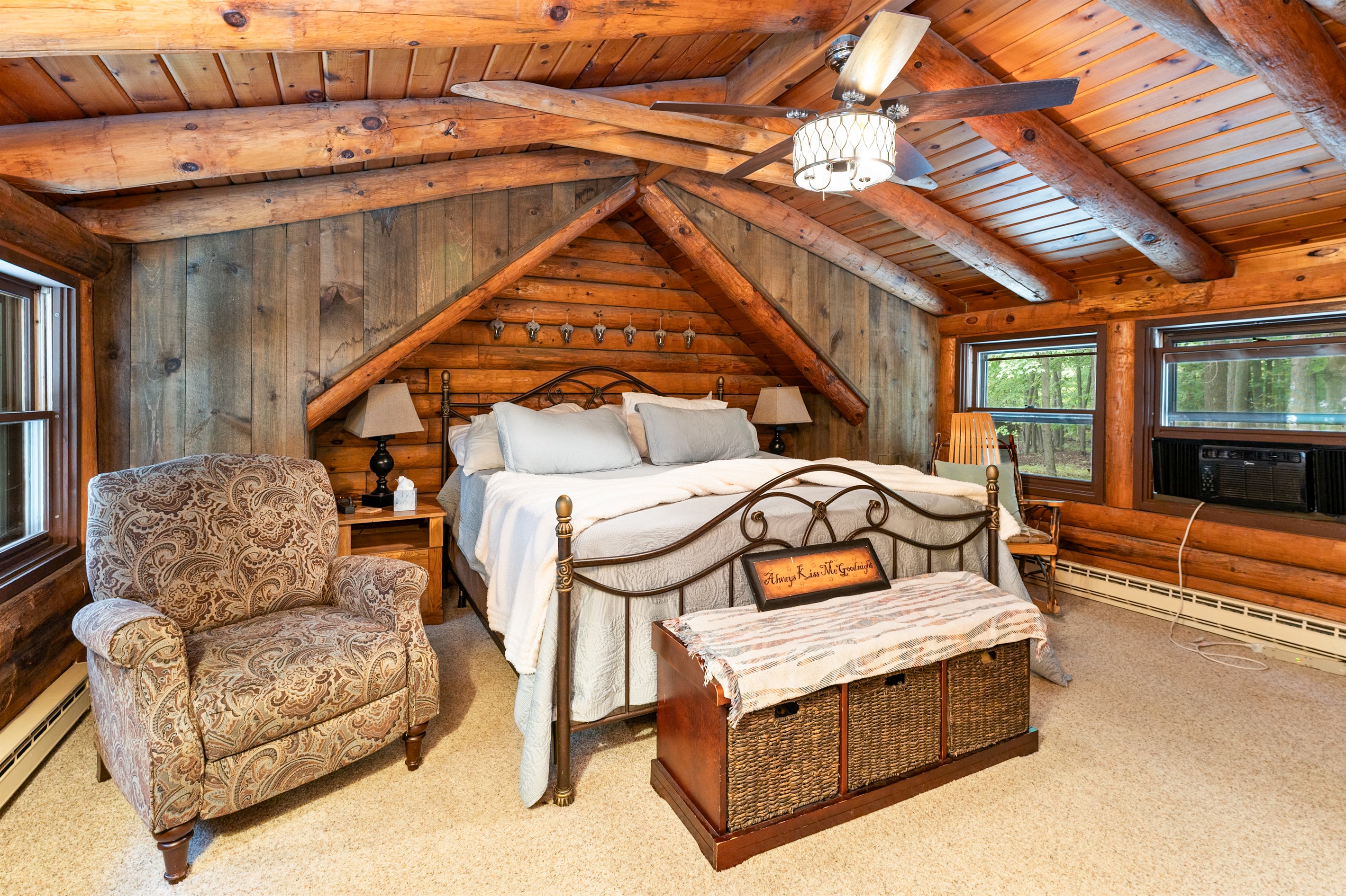 Bedroom #1 Rustic charm meets comfort in this cozy log cabin Master bedroom, featuring a king bed, vaulted ceilings with exposed beams, and serene woodland views. Ensuite bathroom 