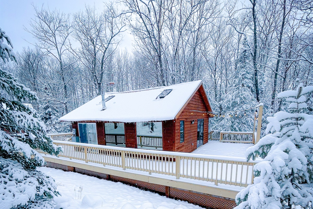 Main Cottage winter views side view looking at two large panoramic windows. String lights. View in winter view snow accumulation possible (Dec, Jan-March) all-wheel-drive or four-wheel-drive vehicle recommended slightly Incline driveway.