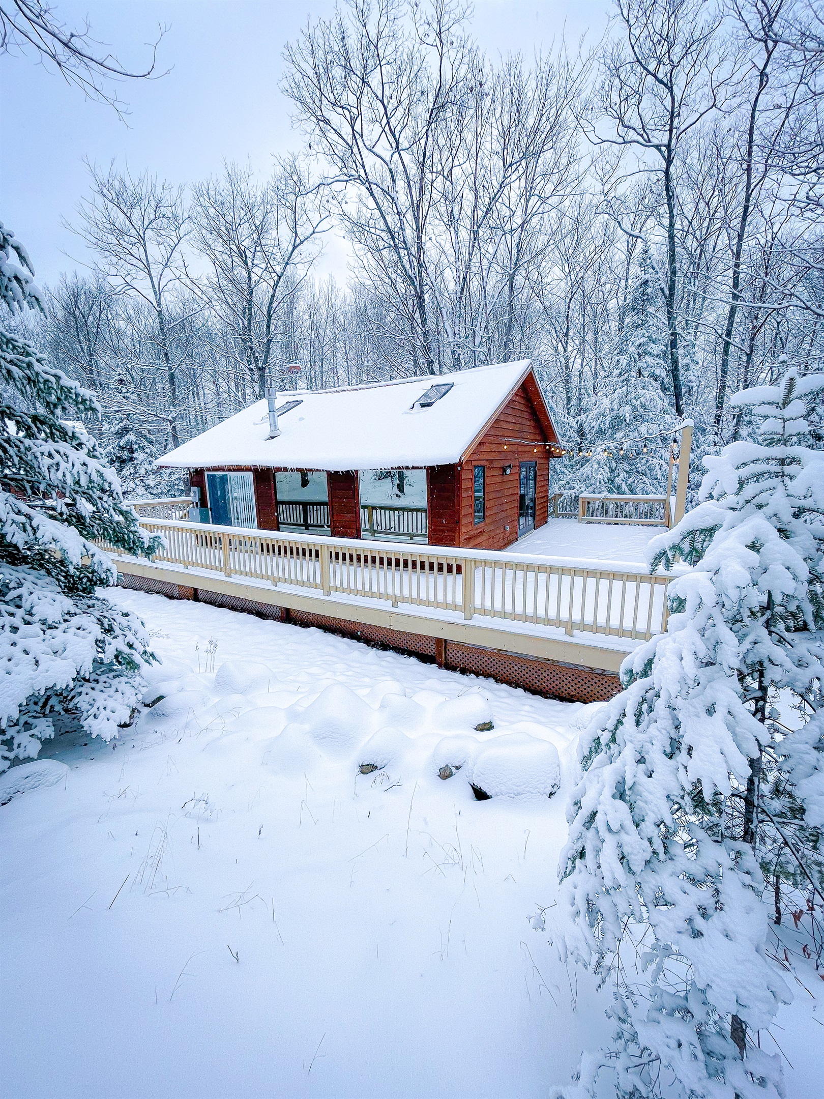 Main Cottage winter views side view looking at two large panoramic windows. String lights. View in winter view snow accumulation possible (Dec, Jan-March) all-wheel-drive or four-wheel-drive vehicle recommended slightly Incline driveway.