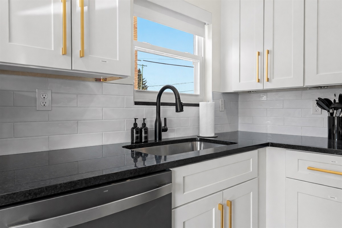 Clean, modern kitchen sink area with sleek fixtures, ample counter space, and natural light—making everyday prep and cleanup feel effortless.