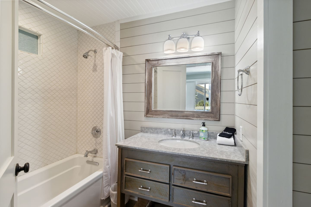Tub/shower combo in the second suite bath &mdash; soak after a day on the beach or rinse off quickly before dinner.