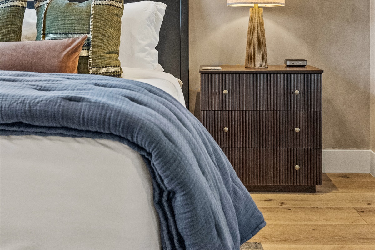 Soft bedding, warm lighting, and thoughtful details create a comfortable space for restful sleep. 