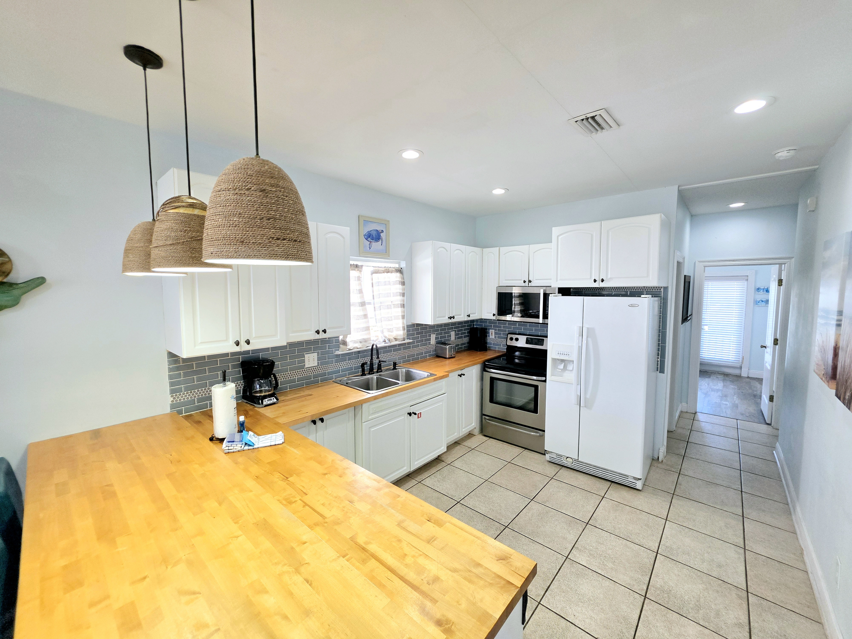 Kitchen with butcher-block counters, stainless range and microwave