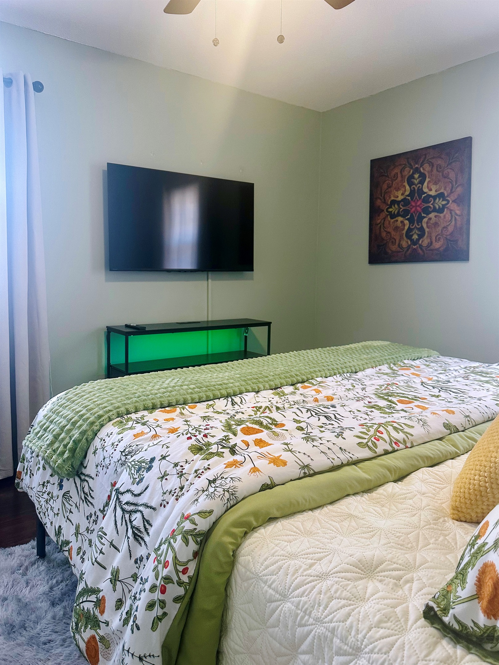 Primary bedroom featuring a wall-mounted TV for relaxed evenings and downtime. This photo highlights the added television, providing a comfortable private space for streaming, winding down, or quiet mornings.