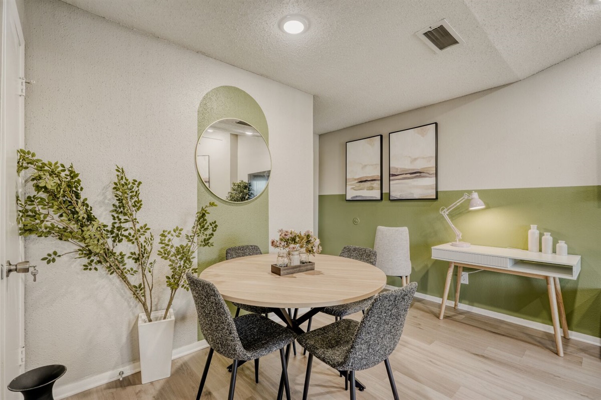 Cozy dining and workspace with modern touches and calming green accents.