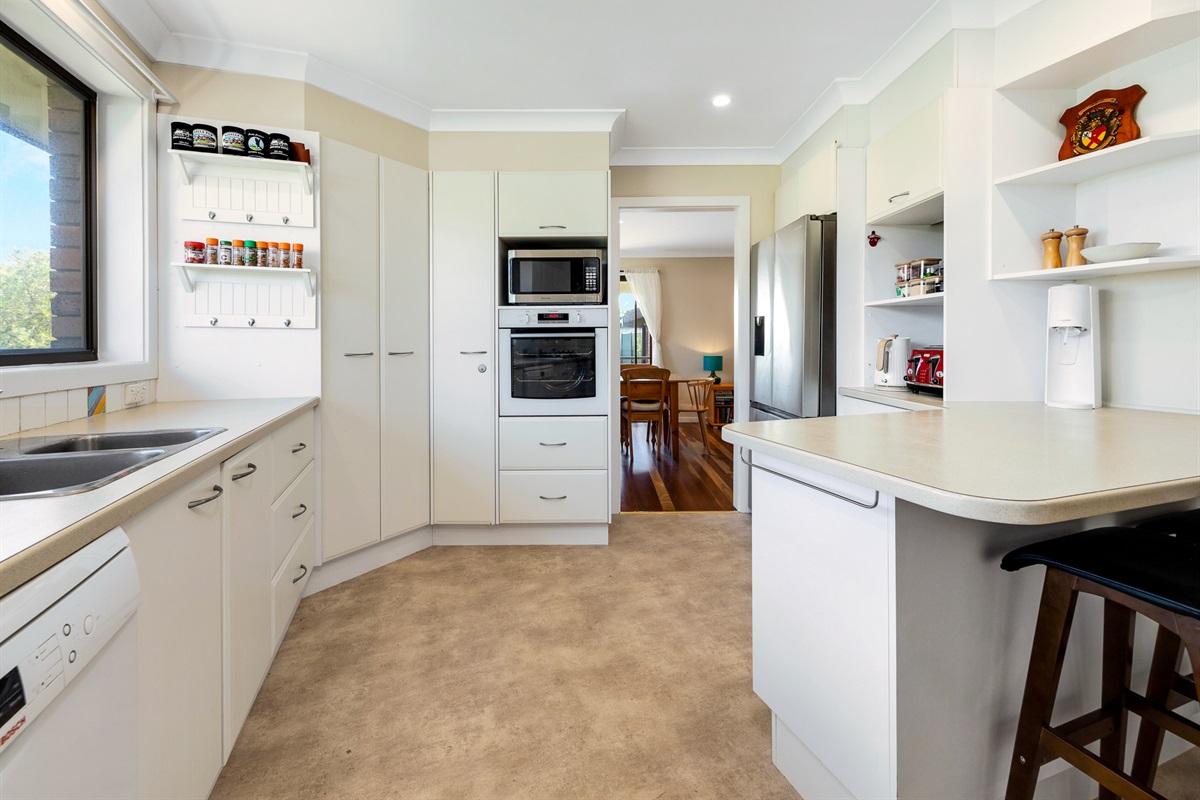 A large upstairs kitchen with bench space, pantry storage and full-size appliances supports shared meals at Bertie’s 3 Beaches.
