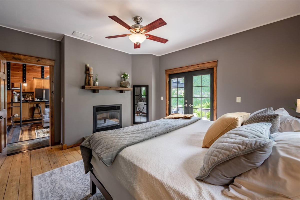 Primary bedroom with gas fireplace and exit to the back deck and hot tub