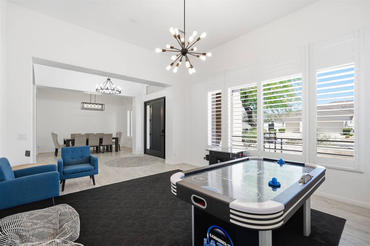Game room with air hockey table and arcade video game table.