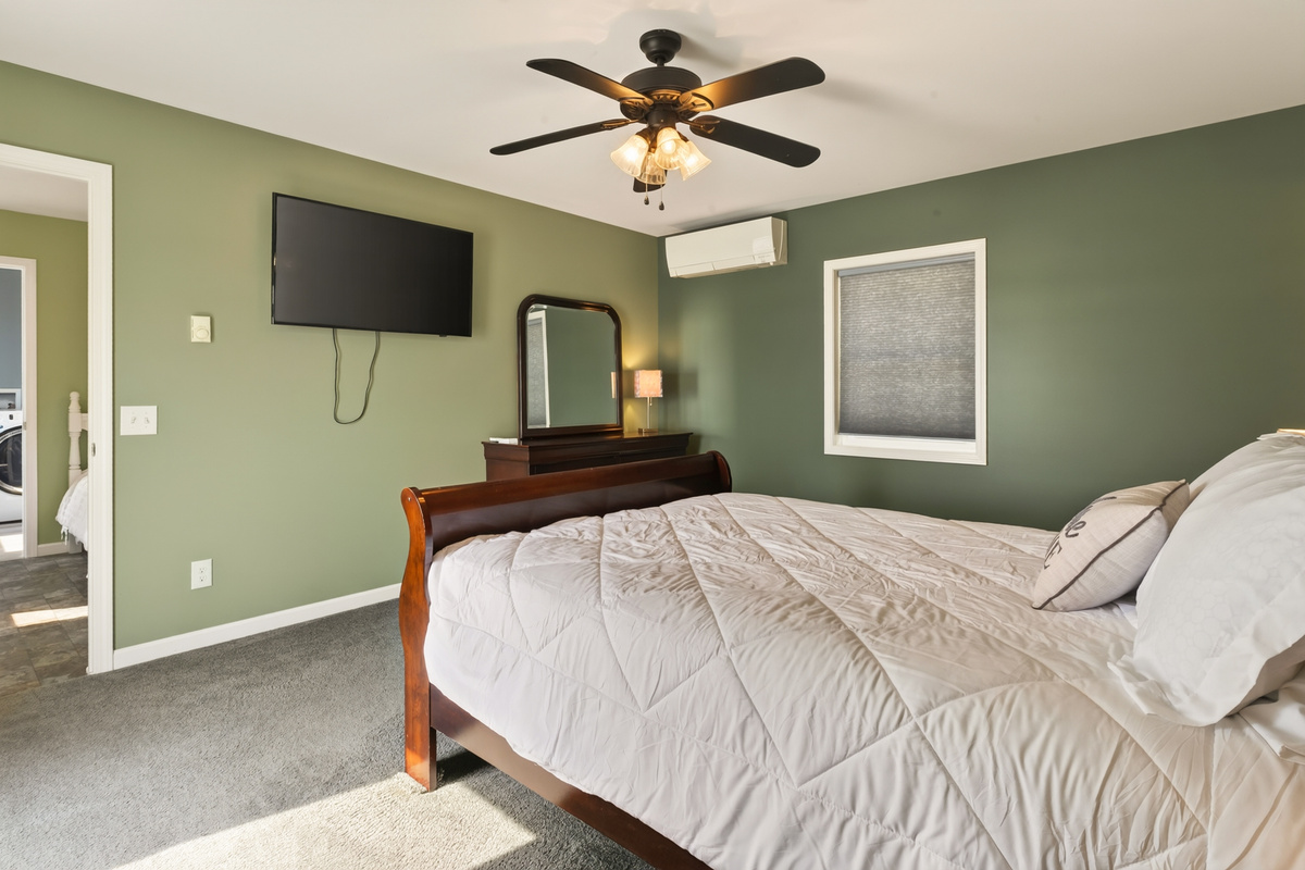 Green bedroom with wood-framed bed