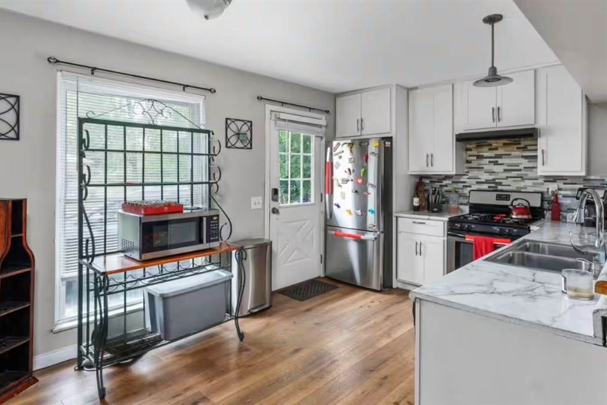 The kitchen area is drenched in soft natural light thanks to tall windows!
