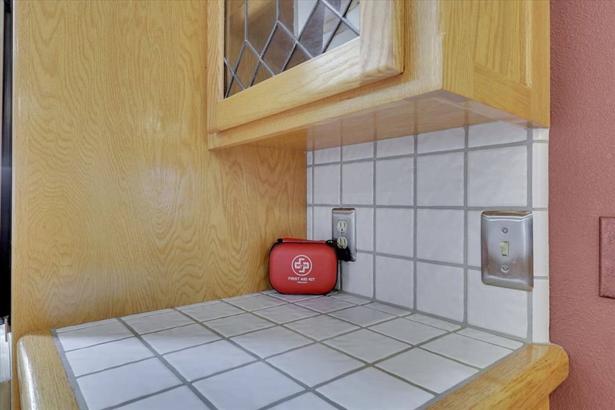 First aid kit stored in the kitchen cabinet area for guest use.
